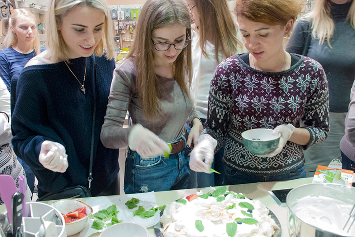 Adding of mint. Christmas Dessert Pavlova Wreath. Cooking class in “My Friends” cooking school.